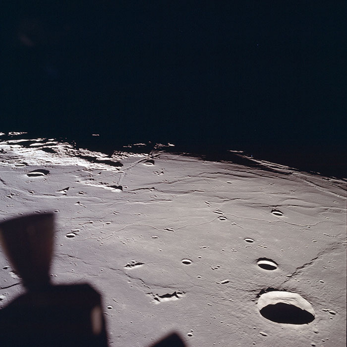 Rauhallisuudenmeri näyttäytyy arvoituksellisena Kuun kiertoradalta. Laskeutumisalueella on aamu, ja varjot ovat pitkiä ja teräviä.